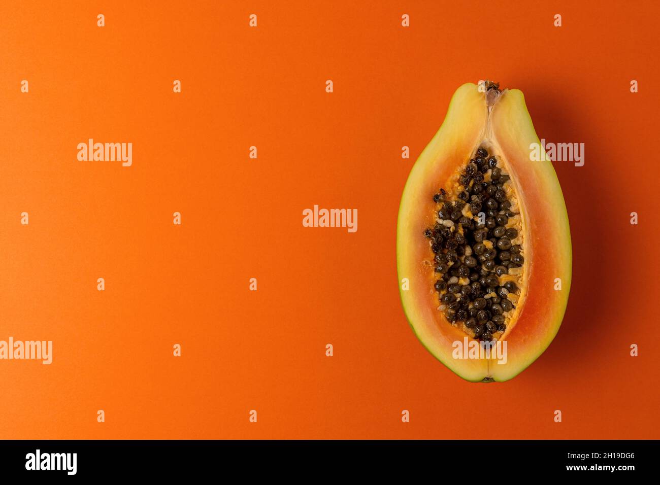 Papaya frutta su sfondo vivace. Concetto astratto estate minimo. Foto Stock