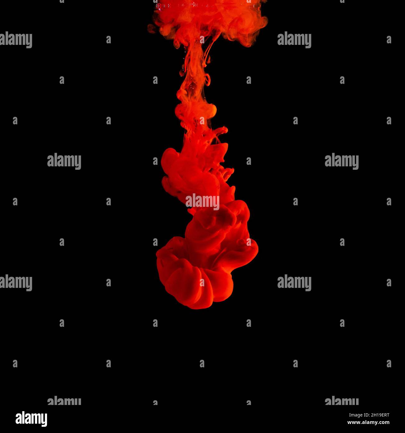 L'inchiostro acrilico rosso spruzza in acqua su sfondo nero. Sfondo astratto minimo. Foto Stock