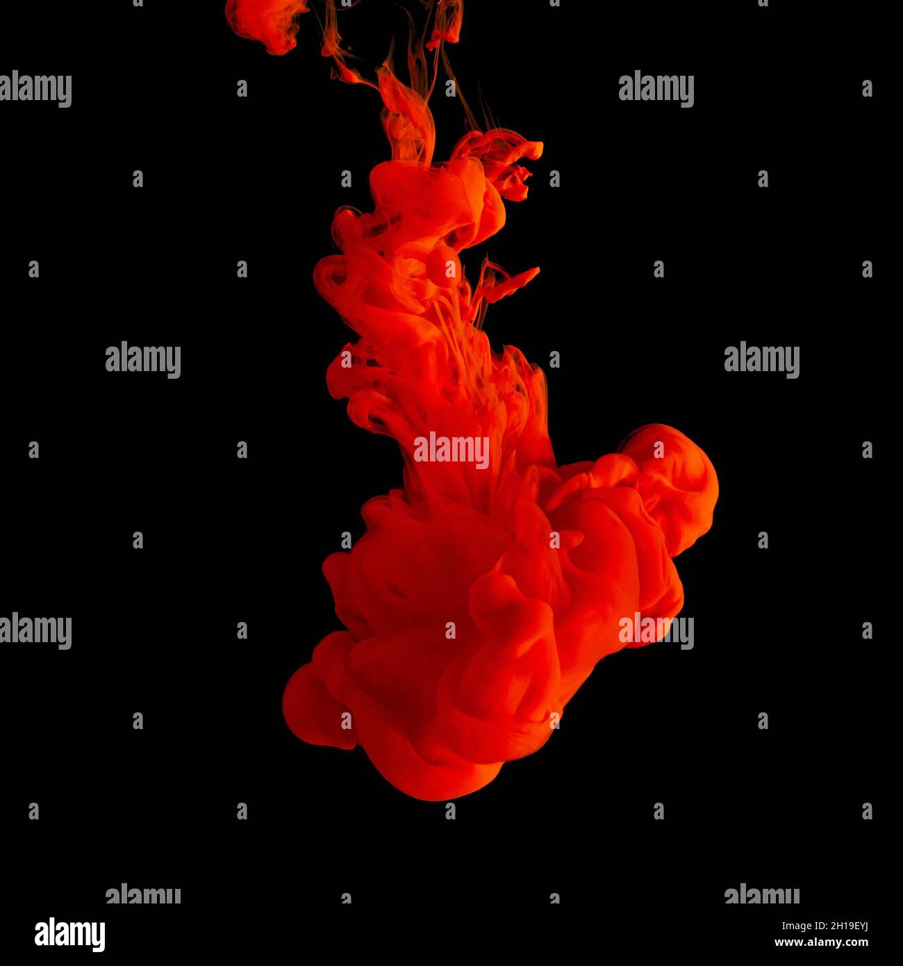 L'inchiostro acrilico rosso spruzza in acqua su sfondo nero. Sfondo astratto minimo. Foto Stock