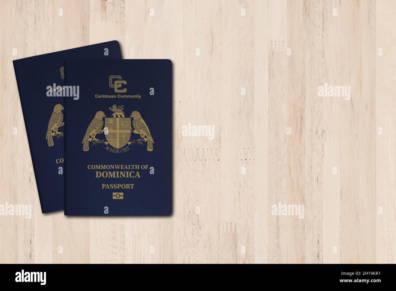 Il passaporto Dominica è rilasciato ai cittadini del Commonwealth di Dominica per i viaggi internazionali, passaporto Dominica su sfondo di legno Foto Stock