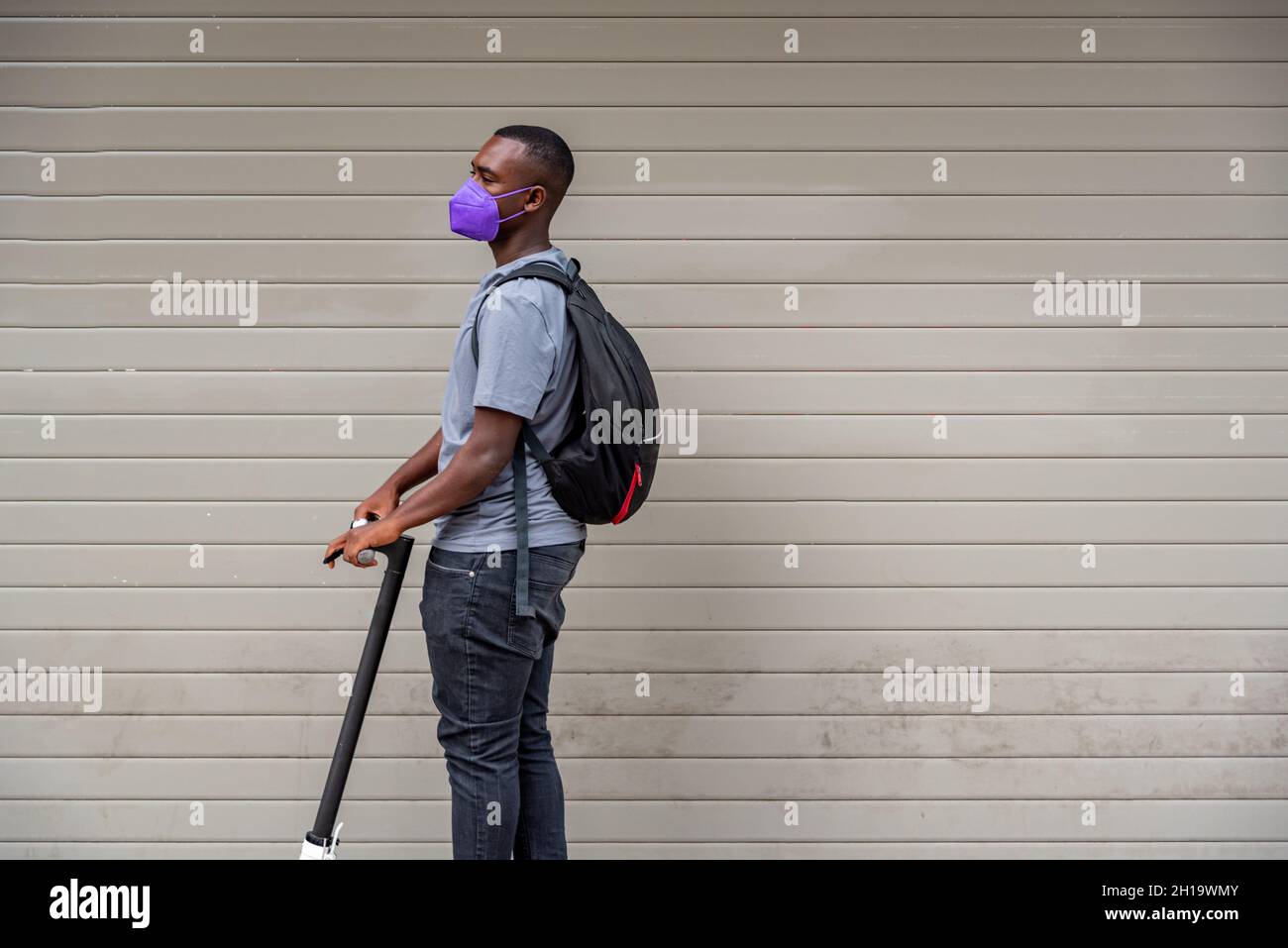 Afro giovane uomo in scooter elettrico all'aperto Foto Stock