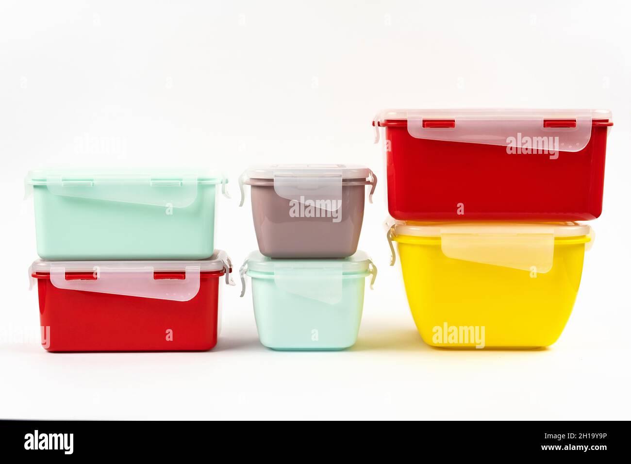 Contenitori multicolore in plastica per prodotti alimentari isolati su sfondo bianco. Pila di scatole per il pranzo. Vista laterale Foto Stock
