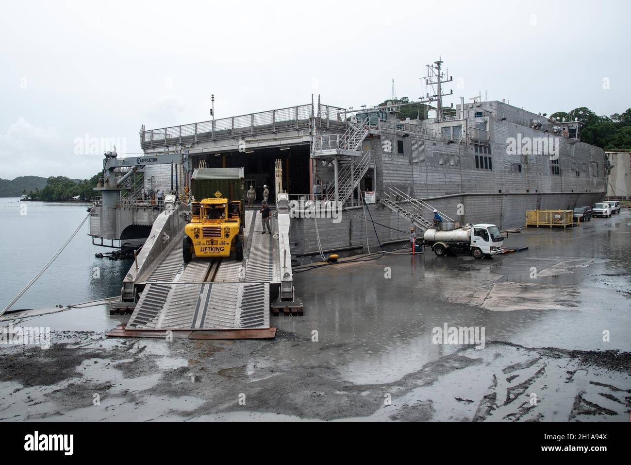 MALAKAL ISLAND KOROR, Palau (dal 23, 2021) Un contenitore di Lightweight Water Purification Systems (LWPS) viene scaricato dal trasporto rapido di classe Spearhead USNS City di Bismarck (T-EPF-9) al porto di Palau per dimostrare le capacità di Seabee a sostegno delle operazioni della flotta. LWPS forniscono ridondanza di acqua dolce a porti austeri senza acqua potabile. L'NMCB 1 è stato implementato in avanti per eseguire lavori di costruzione, assistenza umanitaria, cooperazione per la sicurezza del teatro e supportare la manovra della flotta nelle aree operative della 7a flotta statunitense. (STATI UNITI Foto Navy di Steelworker III Classe Taylor Myer Foto Stock