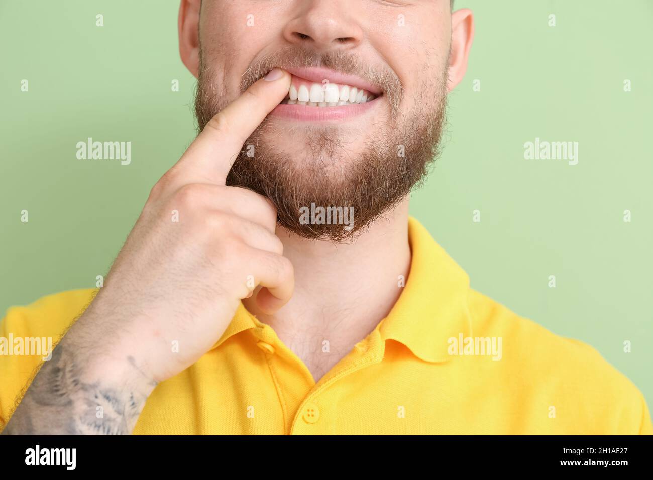Giovane uomo con gengive sane su sfondo colorato, primo piano Foto Stock