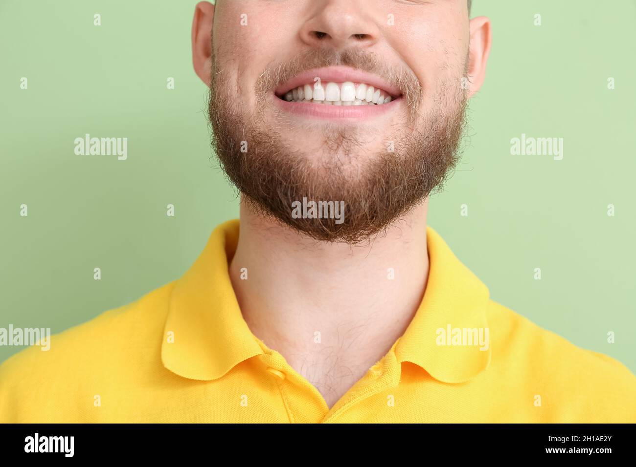 Giovane uomo con gengive sane su sfondo colorato, primo piano Foto Stock