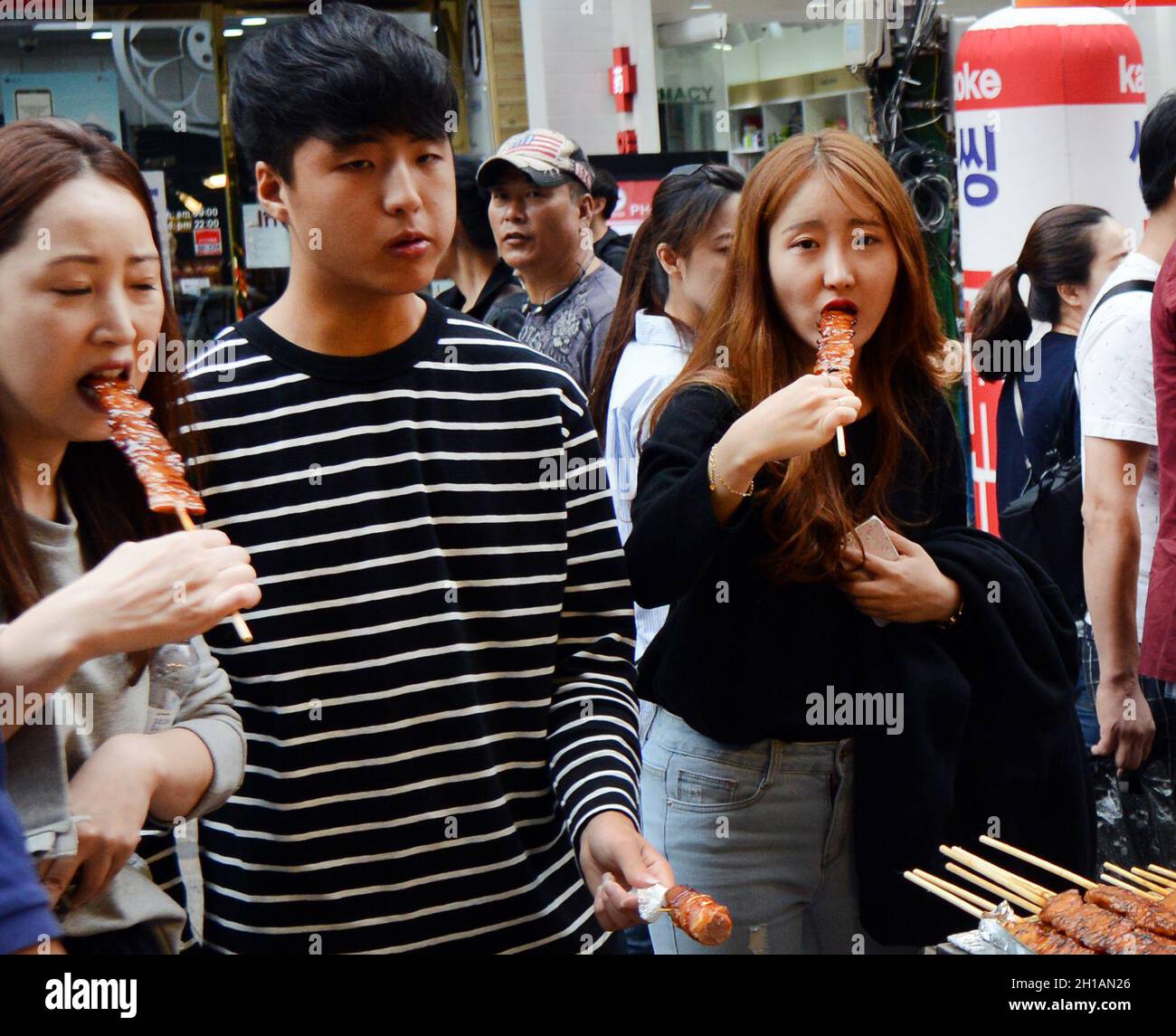 Venditori di cibo di strada nel popolare quartiere dello shopping di Myeongdong, Seoul, Corea del Sud. Foto Stock