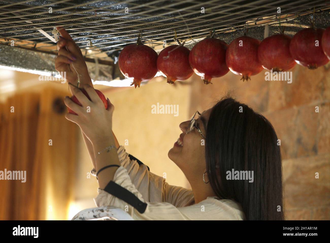 Nablus, Palestina. 17 ottobre 2021. La donna samaritana ha visto appendere frutta e agrumi in preparazione alla tradizionale festa conosciuta come Sikka. I samaritani si preparano per la festa del Trono, conosciuta come Sikka, sul monte Gerizim nella città di Nablus, in Cisgiordania. La setta samaritana è considerata la più piccola denominazione del mondo, con 800 membri. Credit: SOPA Images Limited/Alamy Live News Foto Stock