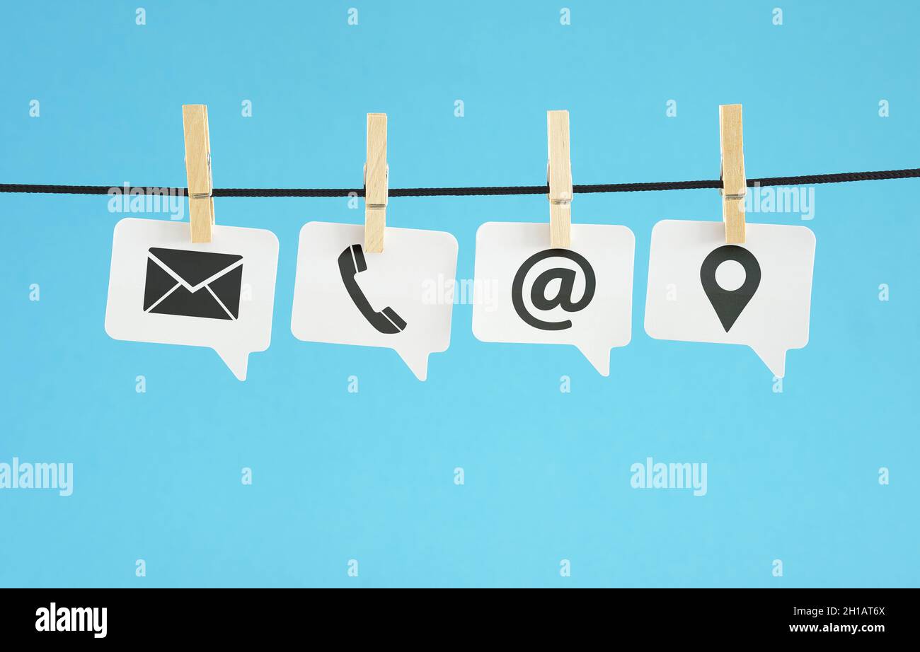 Sito web pagina di contatto concept banner con nero contattaci web icone e simboli su carta bianca fumetti appesi su sfondo blu. Foto Stock
