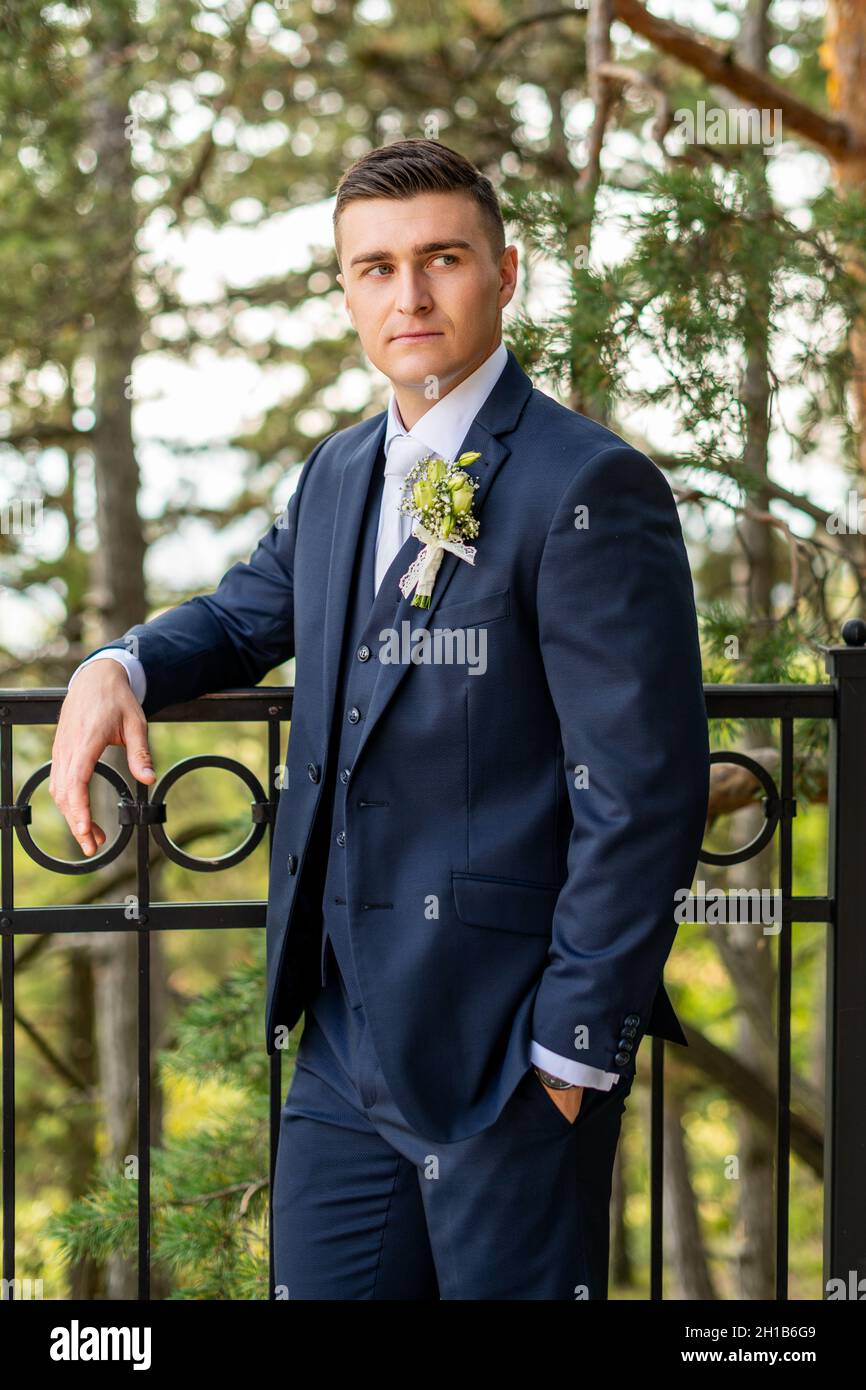 Bel giovane sposo con elegante abito blu scuro ritratto esterno. Moda  elegante Foto stock - Alamy