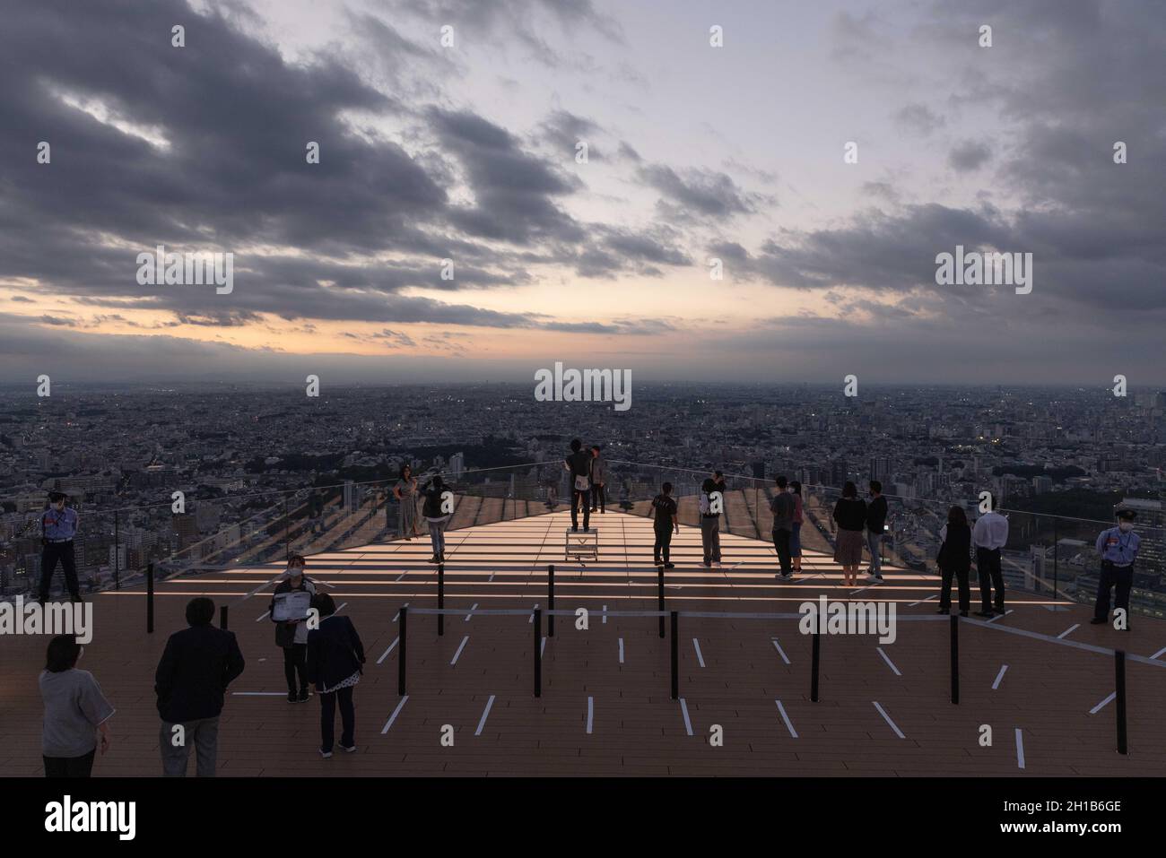 I visitatori di Shibuya Sky scattano foto al piano superiore della piattaforma di osservazione durante il tramonto. Shibuya Sky è una nuova attrazione per i turisti nazionali e internazionali con una splendida vista su Tokyo. Foto Stock