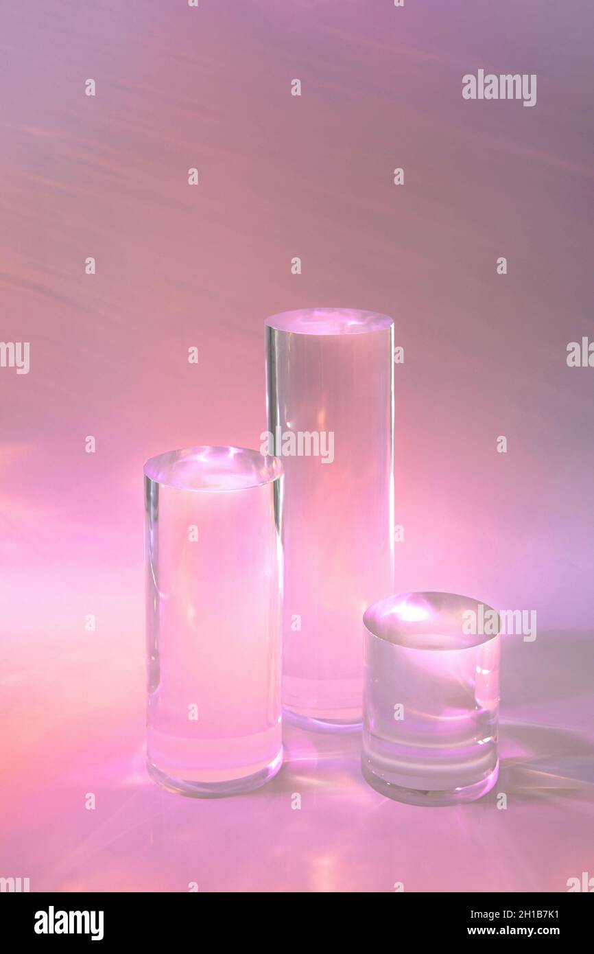 tre podi in vetro chiaro su sfondo rosa pastello Foto Stock