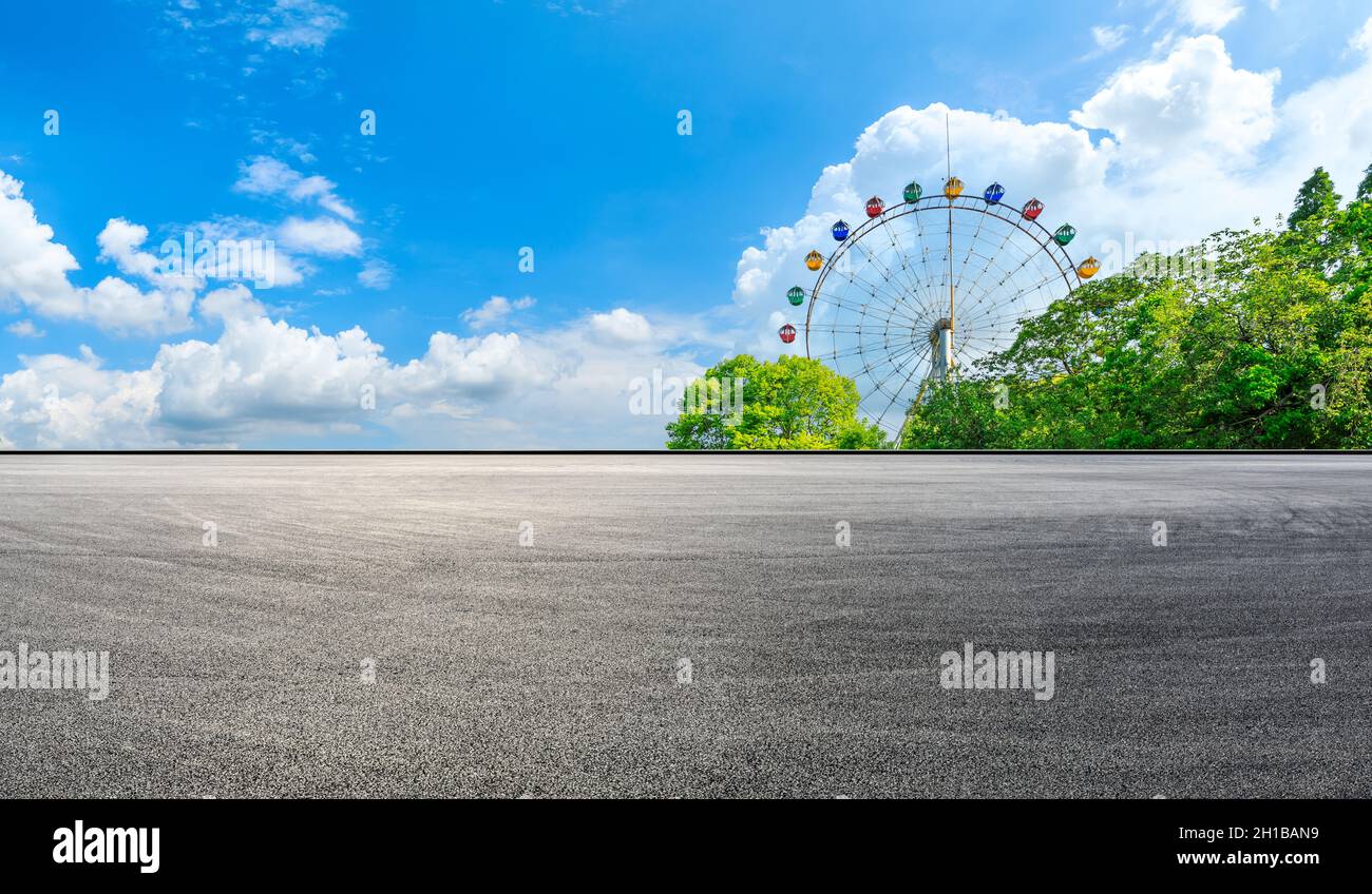 Terreno asfaltato e ruota di ferro con paesaggio forestale verde. Foto Stock