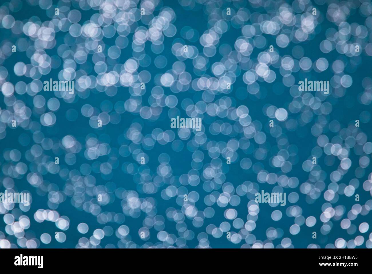 belle luci scintillanti bokeh sfondo chiaro. Sfondo turchese con luci. Foto Stock