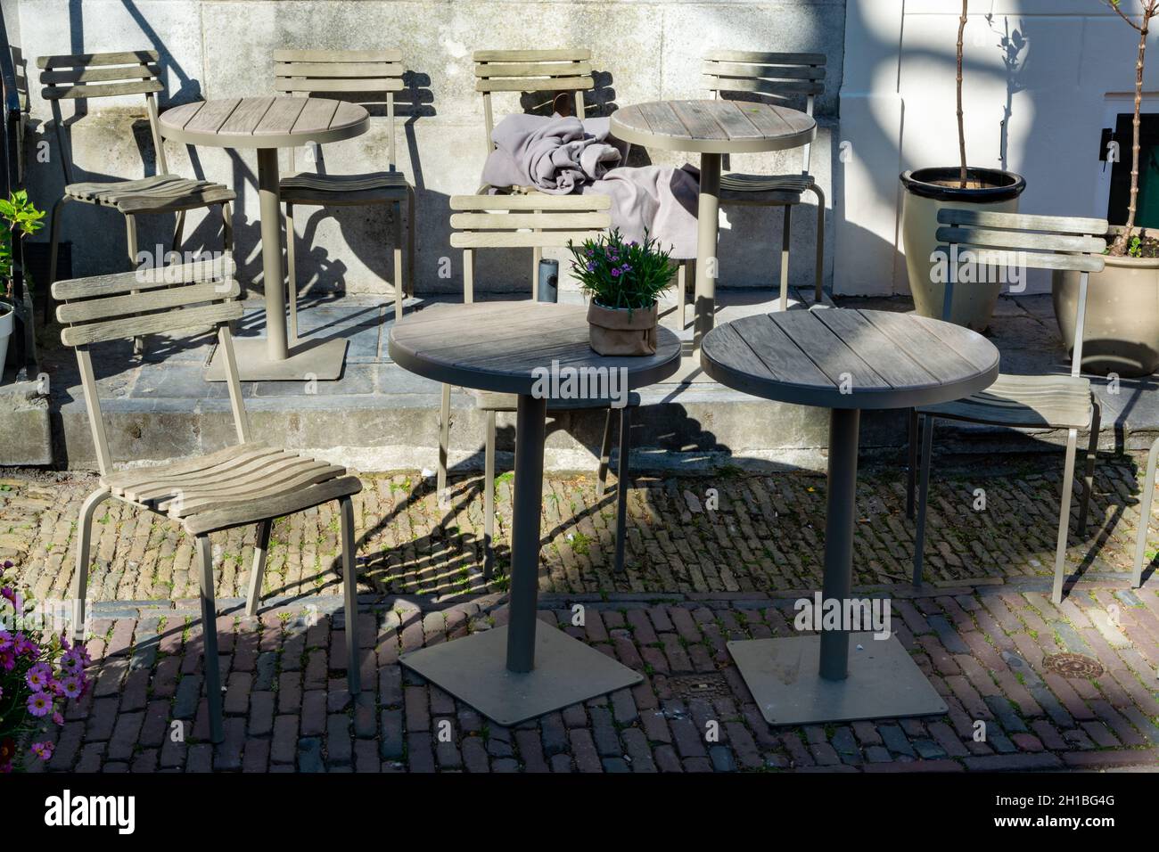 Tavolo da bistrot in metallo d'epoca e sedie allestite in una caffetteria all'aperto, usata per colazione, pranzo e cena sulla terrazza Foto Stock