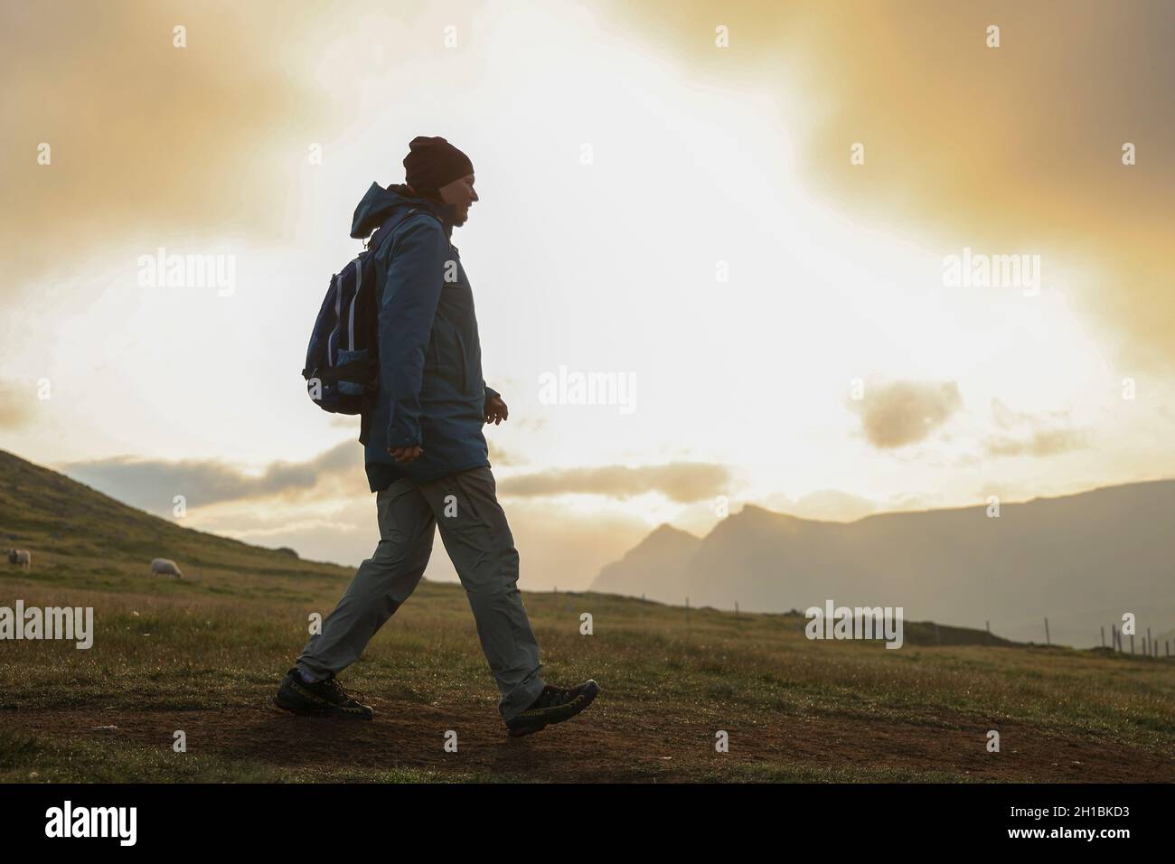 Silhouette di un escursionista al mattino sul monte Slaetteratindur, Isola Eysturoy, Isole Faroe, Scandinavia, Europa. Foto Stock