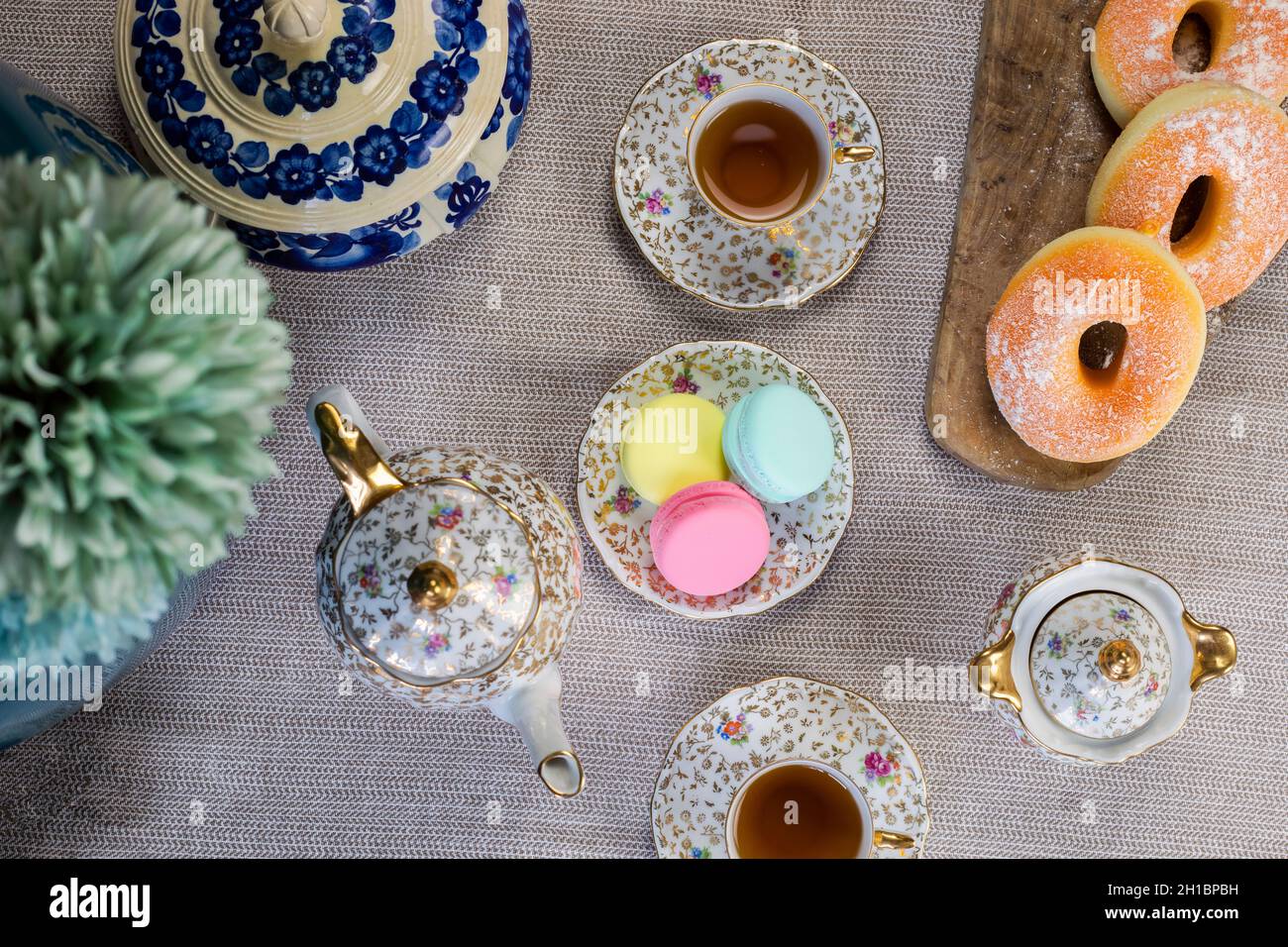 Tavolo tradizionale con tazza di tè e tea pot e macaron colorato grazioso tavolo accogliente a casa, tè del giorno della mamma con teiera, Foto Stock