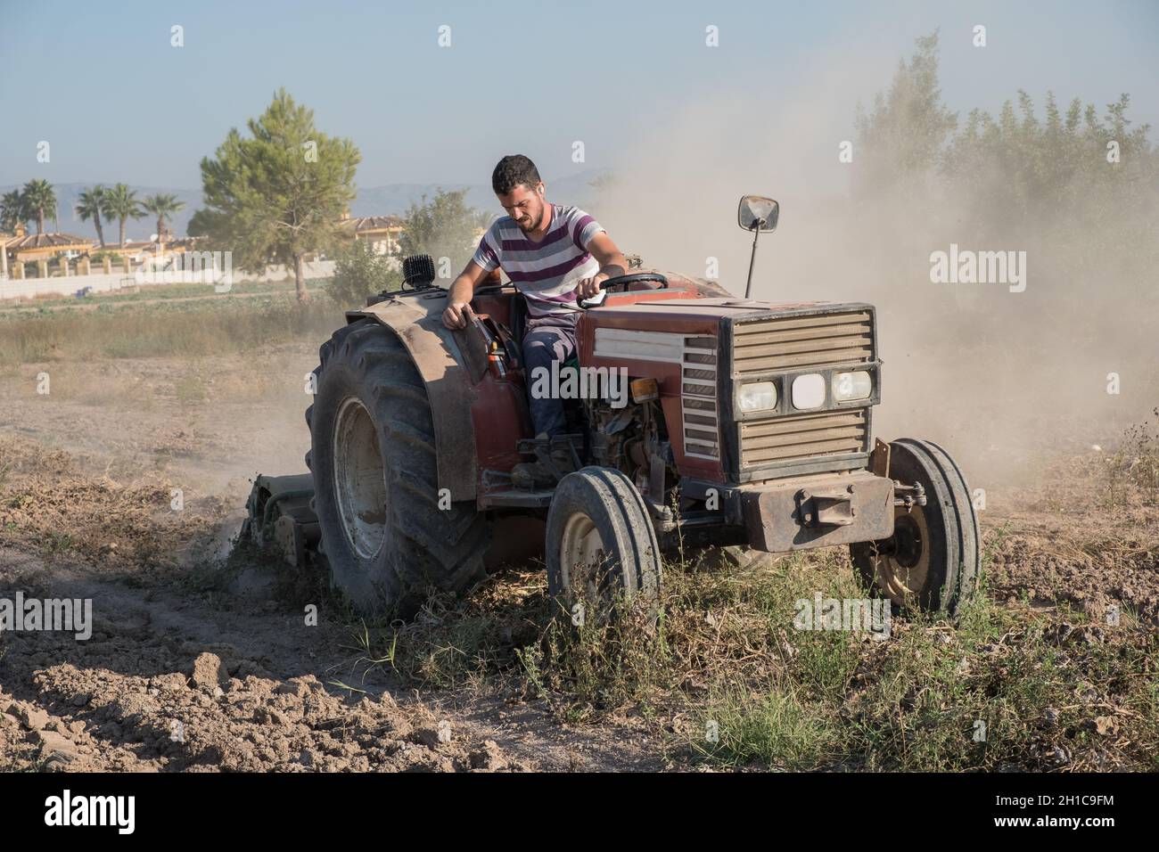 coltivatore arando il terreno in preparazione per il nuovo raccolto Foto Stock