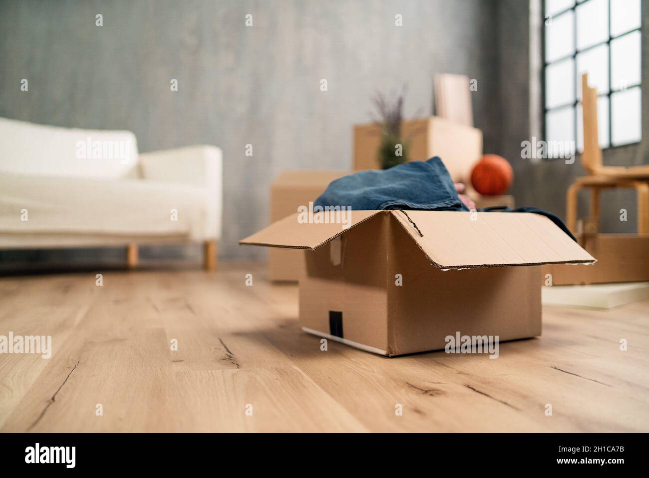 Soggiorno vuoto con scatole di cartone già imballato, concetto di casa in movimento. Foto Stock