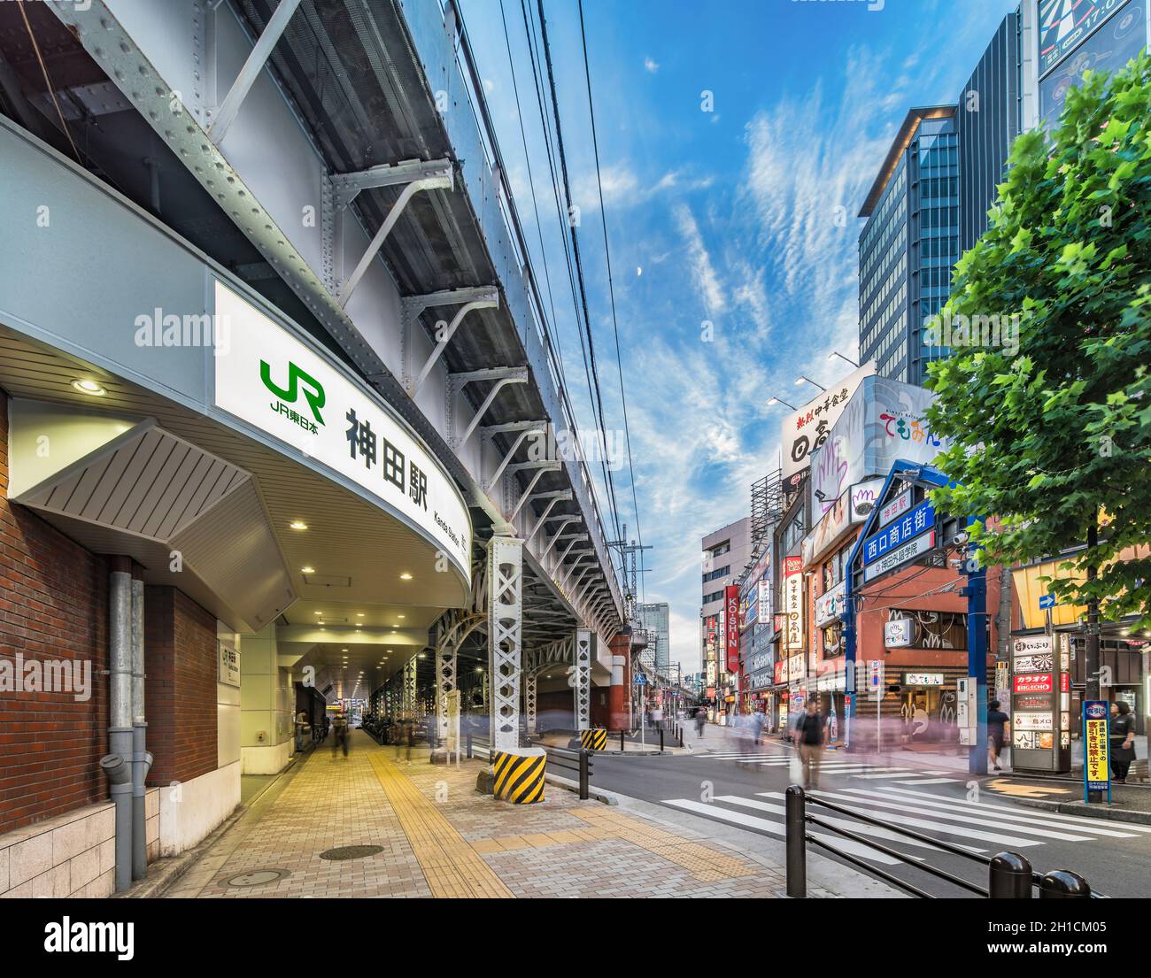 Sottopassaggio con colonna di metallo e cancello d'ingresso blu di via dello shopping dell'uscita ovest della stazione di Kanda sulla linea Yamanote. La strada si estende su Foto Stock