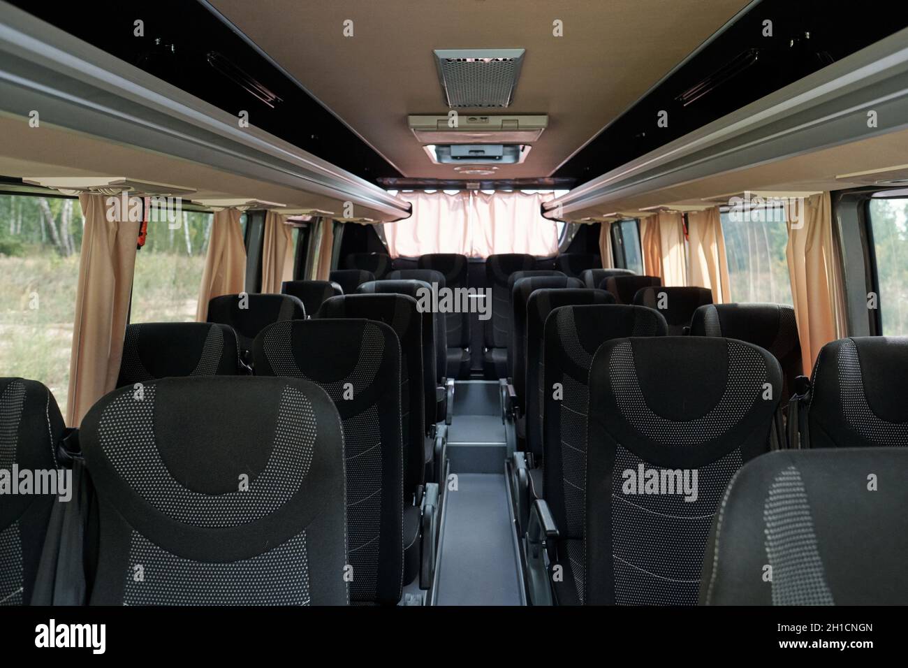 Corridoio lungo circondato da due file di comodi sedili doppi all'interno del trasporto passeggeri contemporaneo Foto Stock
