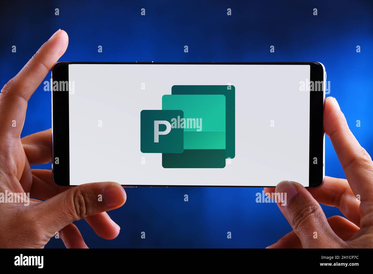 POZNAN, POL - 19 FEBBRAIO 2020: Smartphone Hands Holding con logo di Microsoft Publisher, un'applicazione desktop publishing, parte della famiglia Office Foto Stock