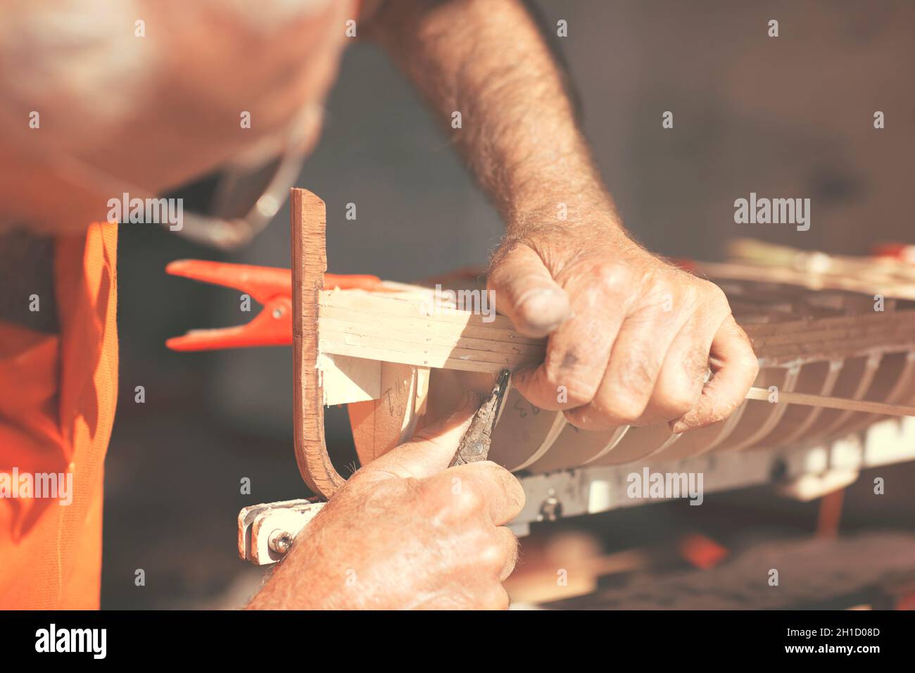 Il vecchio uomo che lavora sulla creazione di un modello in legno di una barca Foto Stock