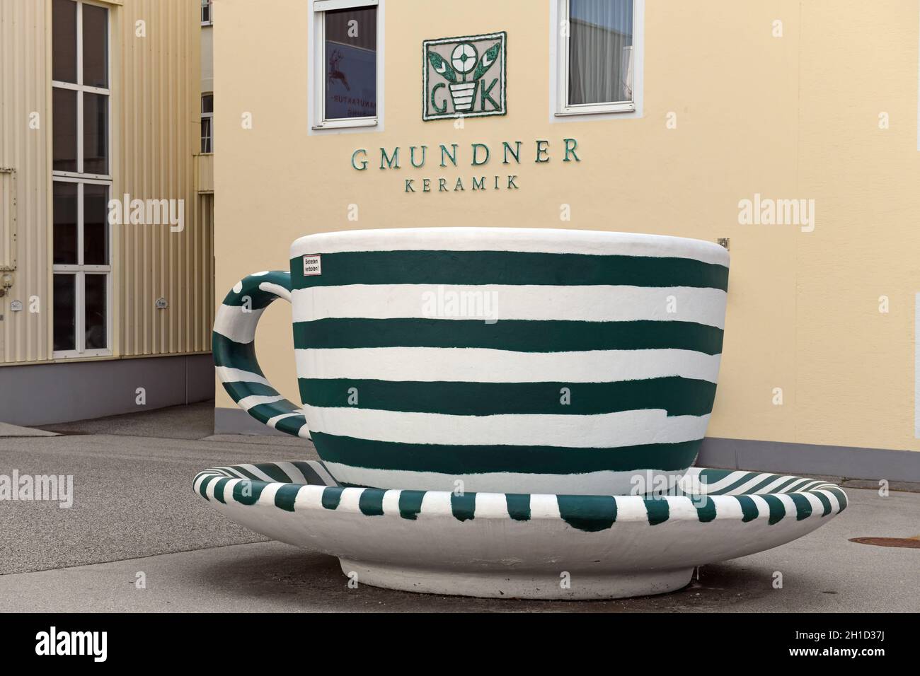 Eingang zur Fabrik der Gmundner Keramik in Gmunden mit einer überdimensionalen Kaffeetasse im typischen Gmundner Streifen-Design - ingresso al GMU Foto Stock