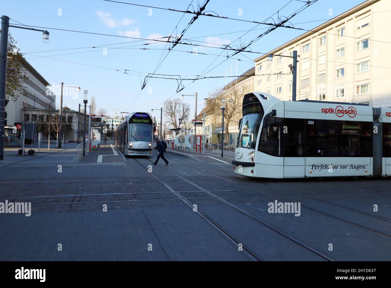 Zwei Straßenbahnen kreuzen sich am fast menschenleeren Europaplatz von Freiburg im Breisgau und das Leben in Zeiten des Corona Virus - Themenbild Medi Foto Stock