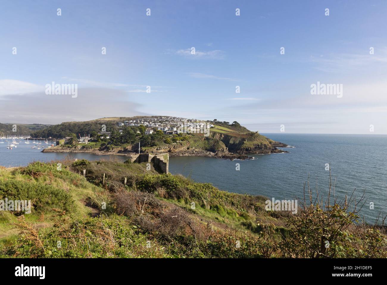 La costa della Cornovaglia all'estuario del fiume Fowey che guarda attraverso il villaggio di Polruan, con il castello di St Catherines in primo piano, Fowey, Cornovaglia UK Foto Stock