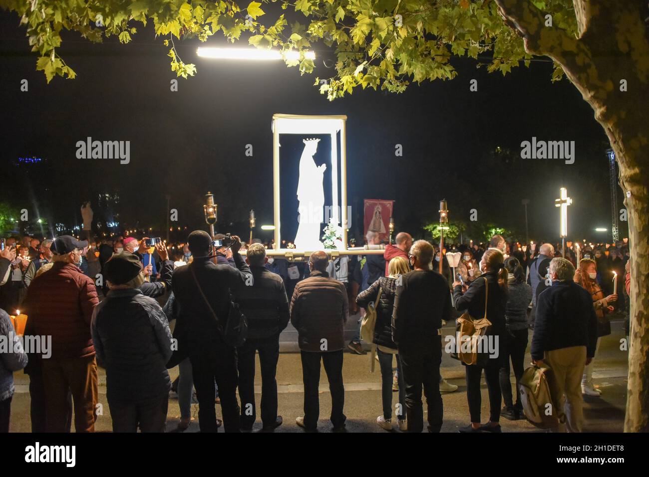 Lourdes, Francia - 9 Ott 2021: Una statua della Vergine Maria viene trasportata tra le folle durante la Processione Mariana Torchlight nella Basilica del Rosario i Foto Stock