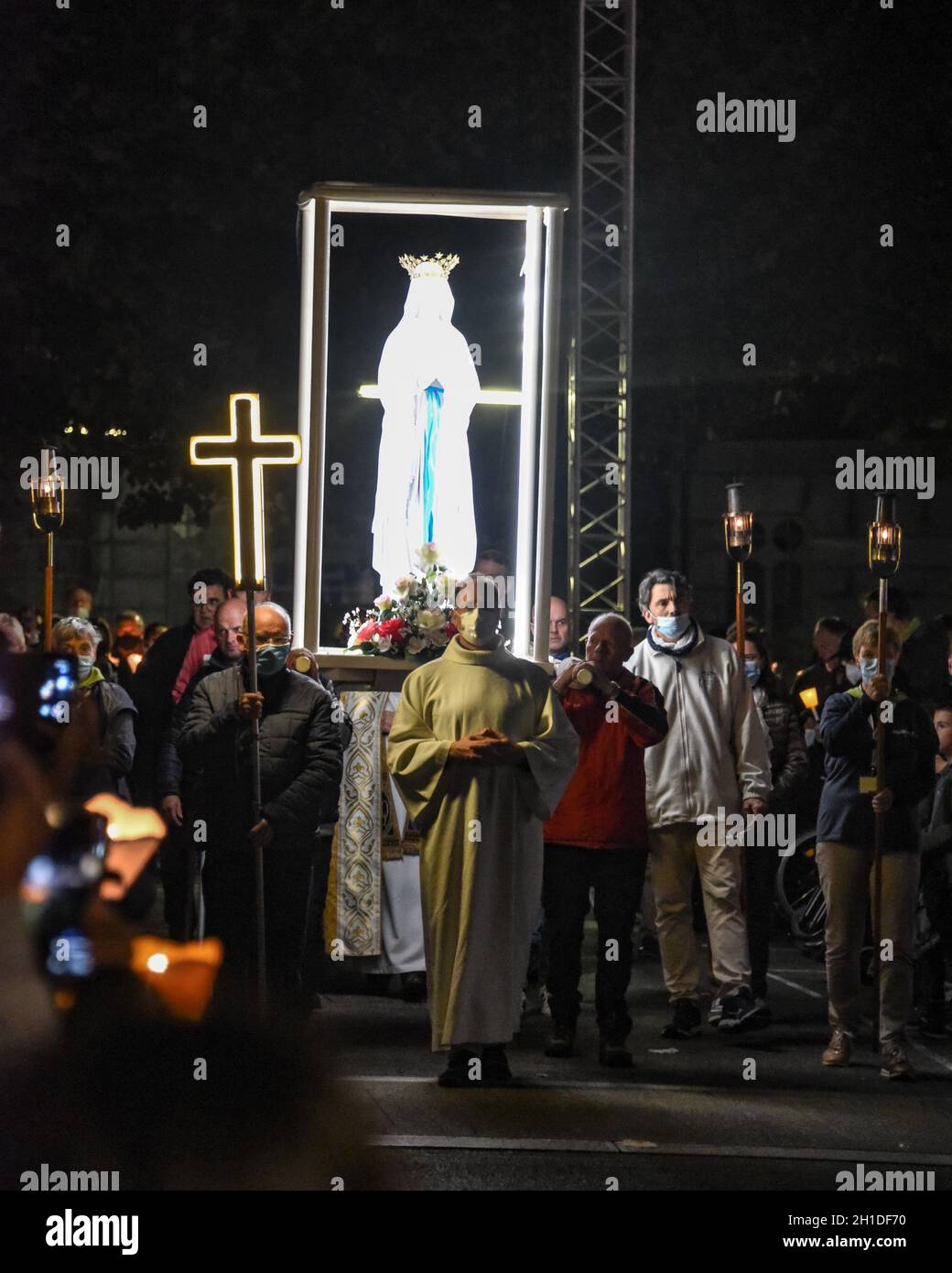 Lourdes, Francia - 9 Ott 2021: Una statua della Vergine Maria viene trasportata tra le folle durante la Processione Mariana Torchlight nella Basilica del Rosario i Foto Stock