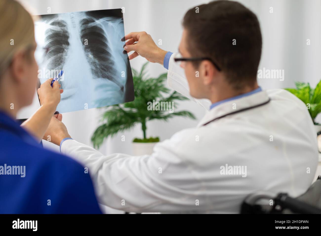 Un medico e un infermiere guardano una fotografia dei polmoni di un paziente. Foto Stock