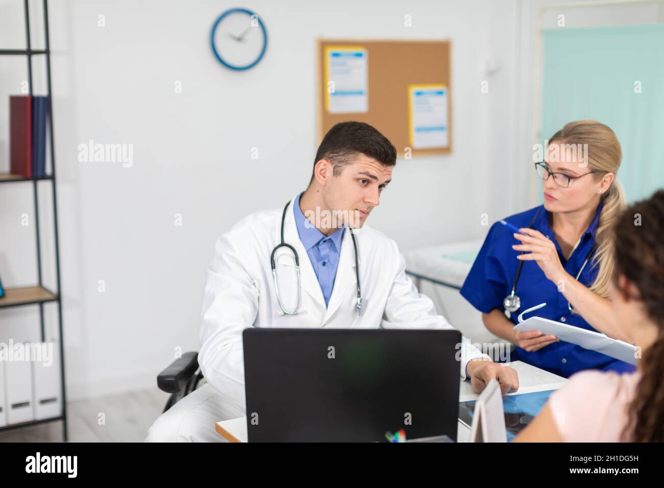 Un medico e una signora medico stanno discutendo una radiografia dei polmoni del loro paziente. Foto Stock