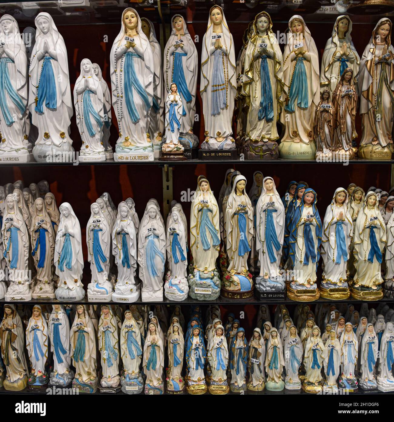 Lourdes, Francia - 9 Ott 2021: Statue figurine della Vergine Maria in vendita presso un negozio di souvenir turistico a Lourdes, Francia Foto Stock