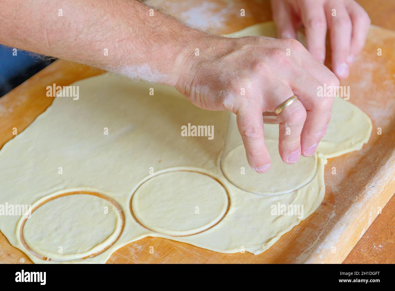 Preparazione di gnocchi o pierogi, preparazione di pezzi arrotondati di pasta con vetro Foto Stock