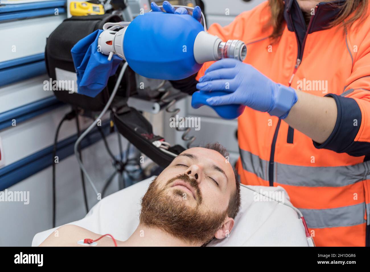 Covid-19 insufficienza respiratoria. Medico d'urgenza usando maschera Ambu sacco su un paziente con polmonite a causa di infezione da Coronavirus, per ventilazione artificiale Foto Stock