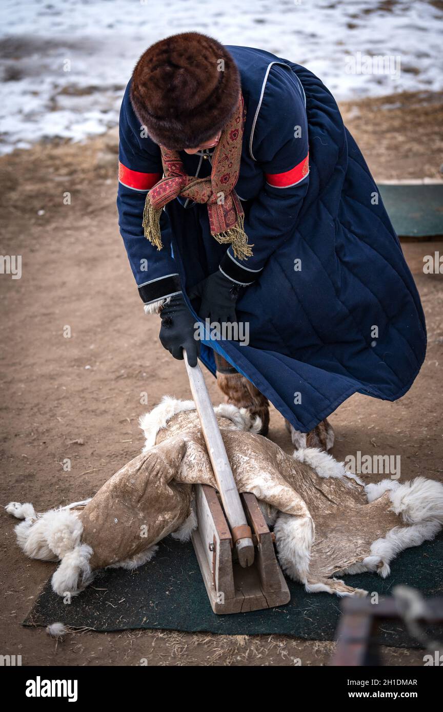 09/03/2020, Buryatia Repubblica, vicino Ulan-Ude, Siberia, Russia : la donna Buryat con vestiti etnici sta lavorando tan pelle animale nella tradizionione Foto Stock