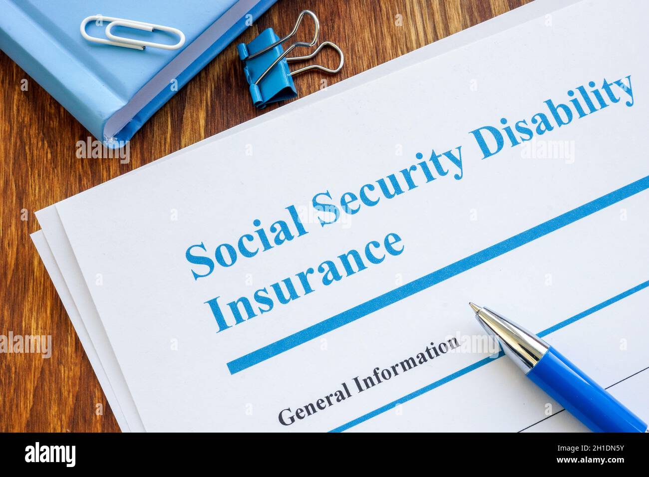 Modulo di richiesta SSDI e penna per l'assicurazione sulla disabilità di previdenza sociale. Foto Stock