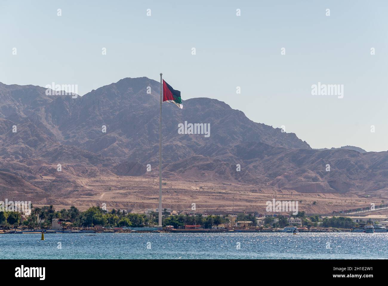 Aqaba Giordania - 6 Novembre 2017: Bandiera della Giordania sventolare sopra la città. Bandiera araba di Revolt-Sixth più alto pennone del mondo. Foto Stock