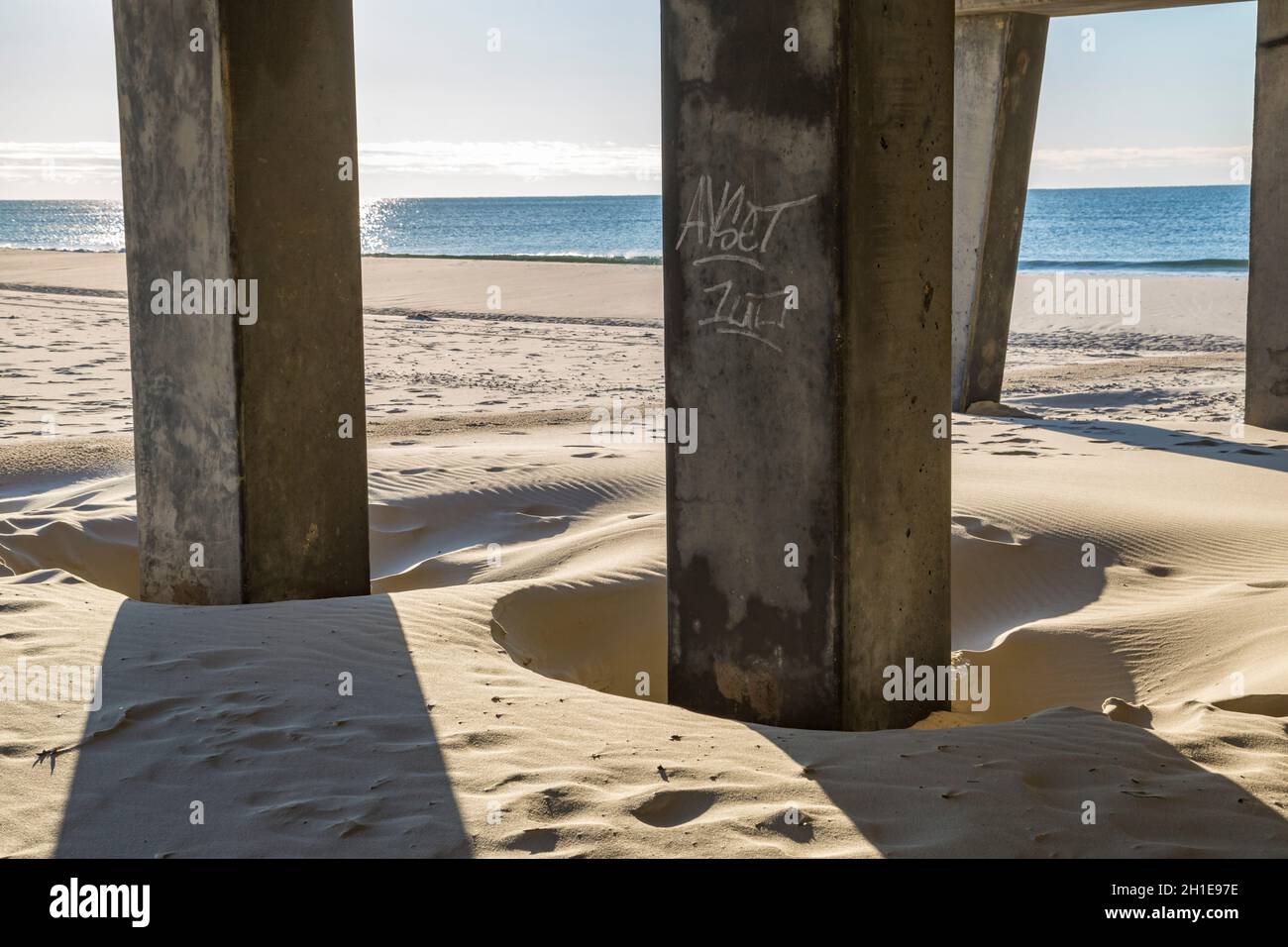 La sottostruttura del molo di pesca del Gulf state Park all'alba crea modelli interessanti sulla spiaggia di Gulf Shores, Alabama Foto Stock