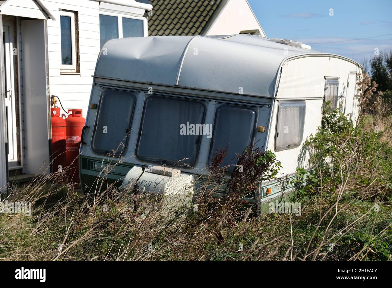 Derelitto tour caravan fuori mare bungalow. Foto Stock