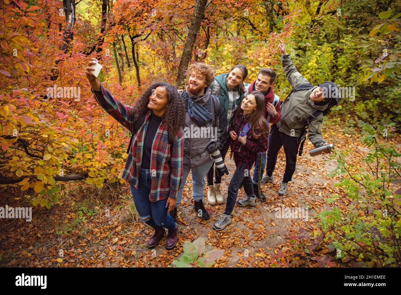 Gruppo di giovani, amici gioiosi che fanno selfie durante le escursioni, trascorrere il tempo togeter nei fores Foto Stock