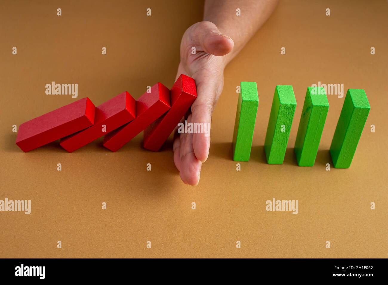 Close up donna business mano di arresto blocchi di legno da cadere. Concetto di gestione dei rischi e delle crisi nella vita aziendale. Foto Stock