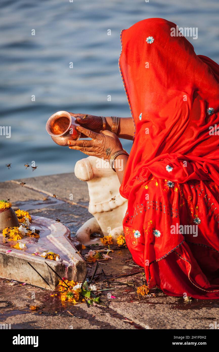 MAHESHWAR, INDIA - APRILE 26: La donna indiana suona la pooja mattina sul fiume sacro Narmada ghats il 26 aprile 2011 a Maheshwar, Madhya Pradesh, India. Foto Stock
