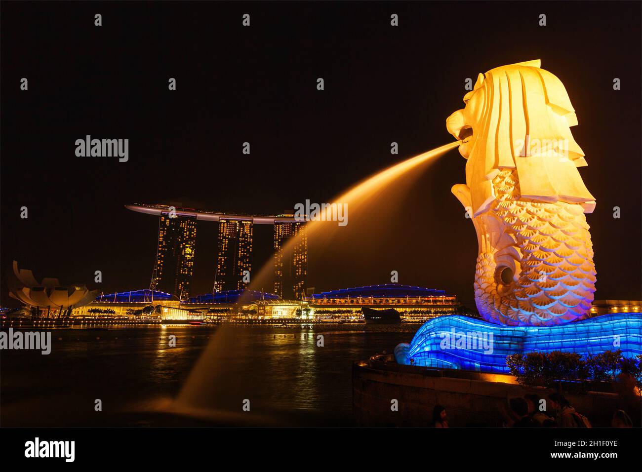 SINGAPORE - 1 GENNAIO 2014: Vista notturna di Singapore Merlion a Marina Bay e Marina Bay Sand Complex. Merlion è una famosa icona turistica, mascotte A. Foto Stock