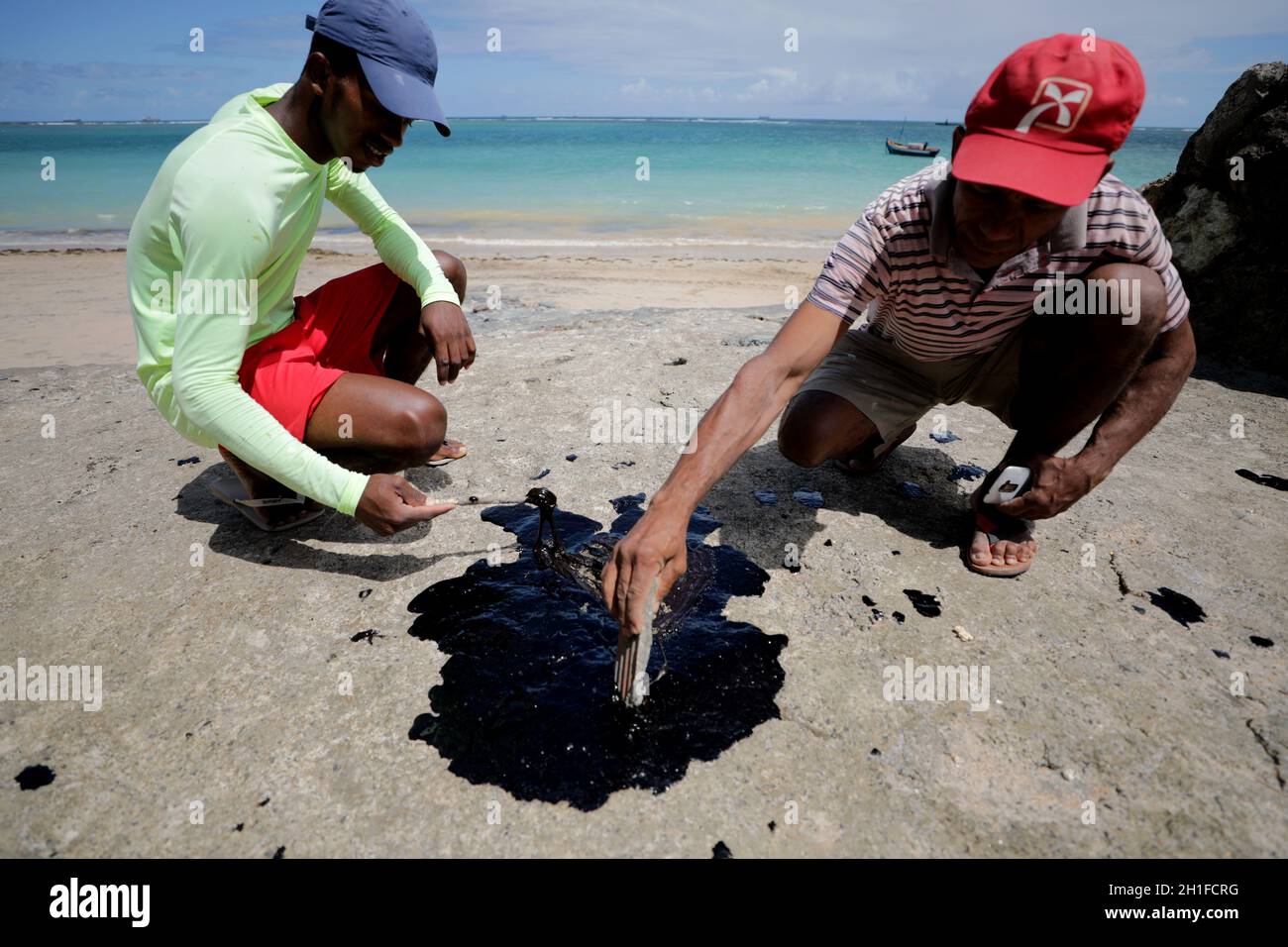 vera cruz, bahia / brasile - 18 ottobre 2019: Le persone ossessionate da olio macha sulla spiaggia di Sol, il luogo è stato colpito da fuoriuscite di petrolio in mare. *** Capt. Locale Foto Stock