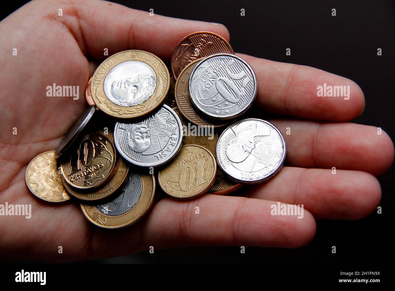 salvador, bahia / brasile - 23 gennaio 2015: La mano contiene monete reali, denaro brasiliano. *** Local Caption *** Foto Stock