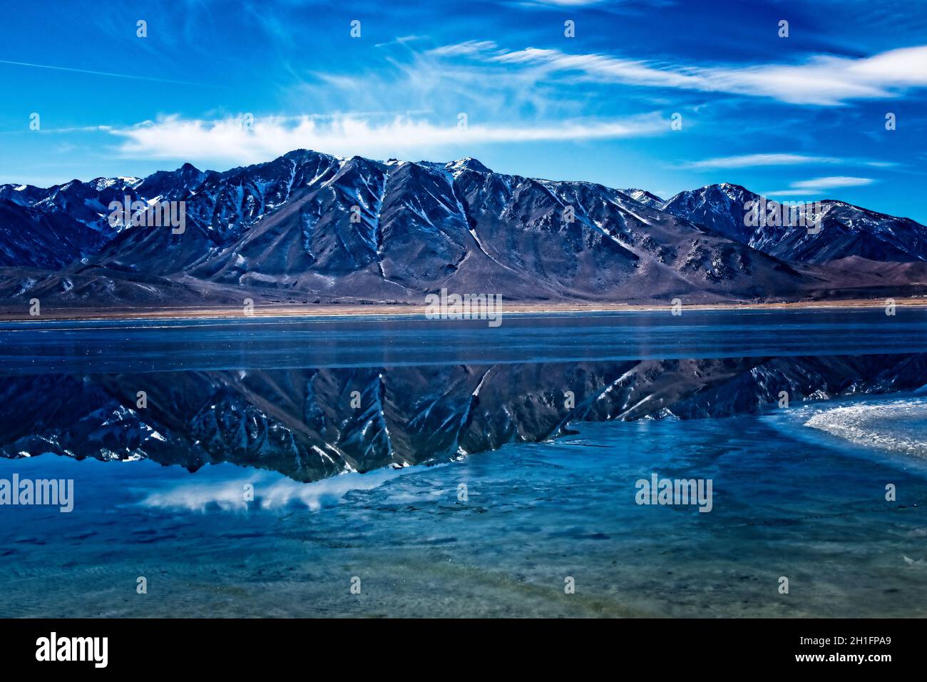 Riflessi del lago Crowley - sulle rive orientali del lago Crowley, un po' ad est di Mammoth, guardando verso i Sierras, con un po' di ghiaccio sul lago. Foto Stock
