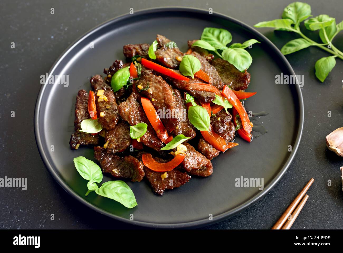 Frittura di manzo tailandese con pepe e basilico sul piatto, vista ravvicinata Foto Stock
