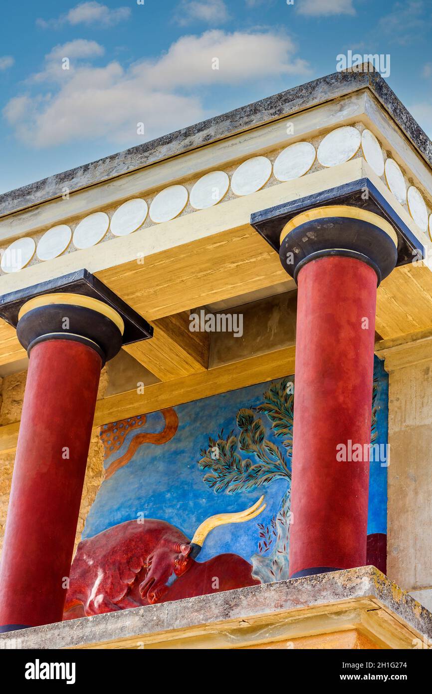 Il Palazzo Minoico di Cnosso con le sue colonne caratteristiche e un affresco di una bolla alle spalle. Creta, Grecia. Foto Stock